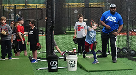 Players training with a coach at a D-BAT academy